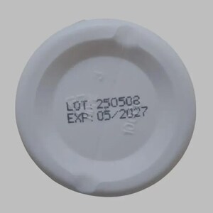 以下が含まれることがあります： 「LOT: 250508」と「EXP: 05/2027」の黒い文字が印刷された白いプラスチック製の蓋。蓋は円形で、中央がわずかにくぼみ、縁に小さなへこみがあります。