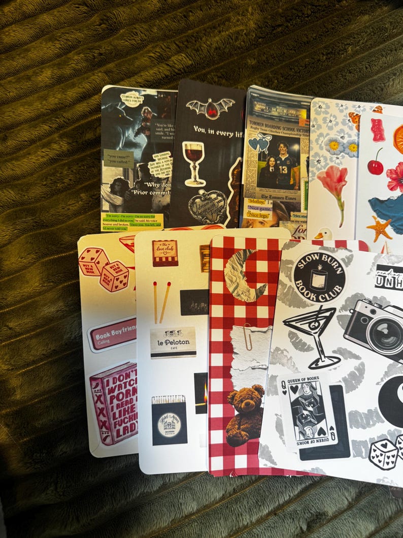 May include: A collection of decorative bookmarks with various designs. Some feature text like "Why don't", "Book Boyfriend", and "I don't watch porn". Other designs include a wine glass, dice, a teddy bear, and a camera.