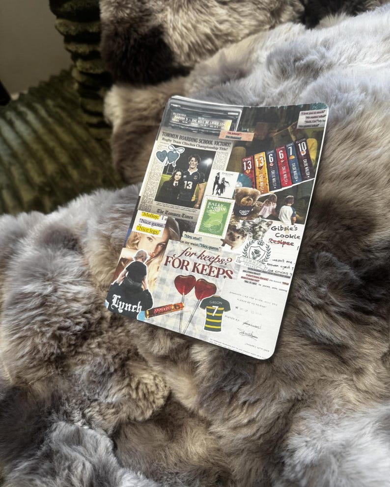 May include: A plush, faux fur blanket in shades of gray and brown. A decorative card with the text "TOMMEN BOARDING SCHOOL VICTORY" and "for keeps? FOR KEEPS" is on top of the blanket. The card also features images and text.