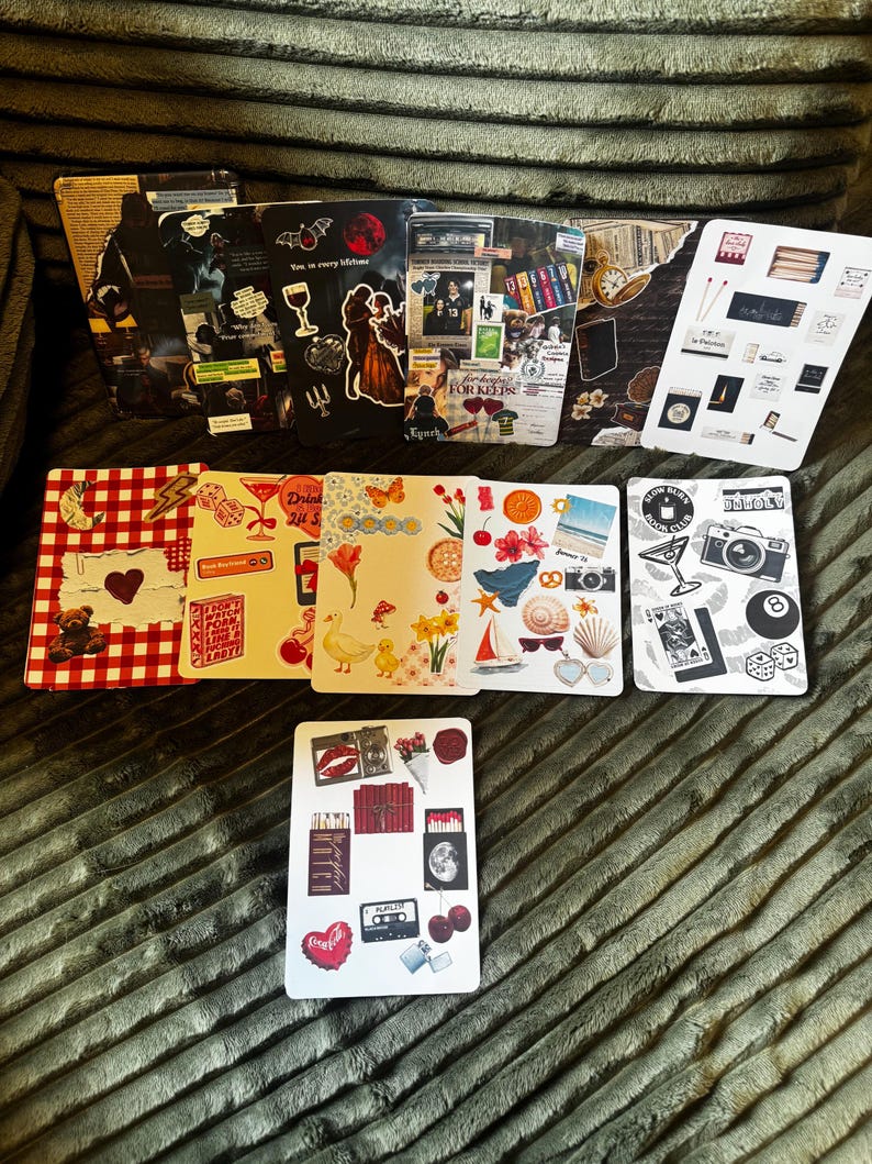 May include: A collection of decorative cards with various designs. Some cards feature collages with images of a couple, a wine glass, and a bat. Other cards have images of a camera, a sailboat, and a heart-shaped Coca-Cola logo.