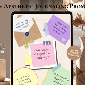 Può includere: Un download digitale con suggerimenti di journaling estetici su un tablet. I suggerimenti sono su note adesive colorate e una busta. Il testo include "40+ Aesthetic Journaling Prompts", "Mental Health & Growth" e "Instant Digital Download". Un vaso con fiori secchi è sullo sfondo.