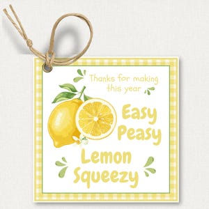 Może przedstawiać: Kwadratowa etykieta prezentowa z żółtą obwódką w kratkę i napisem "Easy Peasy Lemon Squeezy". Etykieta zawiera akwarelową ilustrację cytryny i połówki cytryny z zielonymi liśćmi. Dołączona jest pętla ze sznurka.
