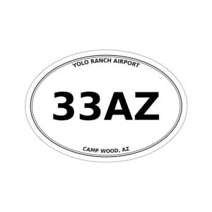 May include: An oval sticker with a white background and a thin black border. The text YOLO RANCH AIRPORT is printed in black along the top curve, the large black text 33AZ is in the center, and CAMP WOOD, AZ is printed along the bottom curve.