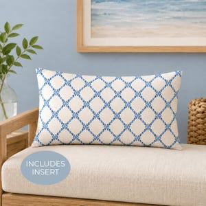 May include: A rectangular throw pillow featuring a cream-colored base with a repeating blue diamond lattice pattern. The design consists of thin blue lines forming a grid with small blue floral accents at each intersection. The text INCLUDES INSERT is visible.