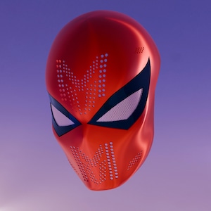 Può includere: Una maschera integrale rosso metallizzato con grandi aperture oculari angolari bordate di nero e lenti a rete bianca. La superficie è decorata con motivi a punti perforati che formano lettere M sulla fronte e sul mento, creando un aspetto strutturato.