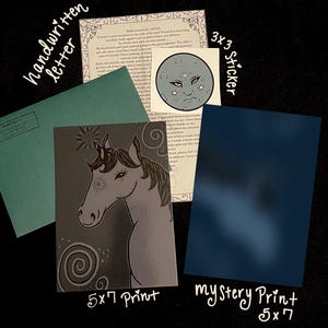 Puede incluir: Un surtido de artículos de papelería, que incluyen una carta manuscrita, una impresión de 5x7 con una ilustración de unicornio, una pegatina de 3x3 con un diseño de cara de luna y una impresión misteriosa. Los artículos están dispuestos sobre una superficie oscura.