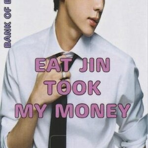 以下が含まれることがあります： ピンク色の「EAT JIN TOOK MY MONEY」の文字が入ったカード。白いシャツと黒いネクタイをした人物が写っています。「BANK OF BANGTAN」の文字が左側に縦書きで印刷されています。
