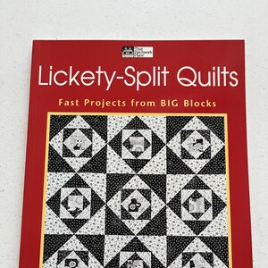 May include: A red book titled "Lickety-Split Quilts" with the subtitle "Fast Projects from BIG Blocks." The cover features a black and white quilt pattern with a gold border. The author's name, Laurie Bevan, is at the bottom.