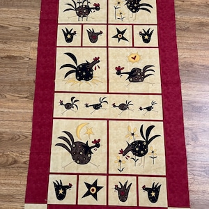May include: A fabric panel featuring a repeating pattern of whimsical chickens in various poses, set against a tan background. The chickens are black with red accents, and the panel has a burgundy border. The text "Do The Funky Chicken" is visible.