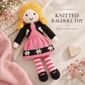May include: A knitted ragdoll toy with yellow hair, wearing a black cardigan and a pink dress with a black hem featuring white daisy patterns. The doll has striped pink and white legs and black shoes, measuring 37.5 cm in total height.