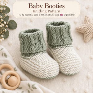 Op de afbeelding: Een paar saliegroene en crèmekleurige babyslofjes met een kabelgebreide boord en een voet in ribbelsteek. De tekst luidt Baby Booties Knitting Pattern, 6-12 maanden: zool is 11,5 cm lang, Engels PDF. Getoond met een houten rammelaar.