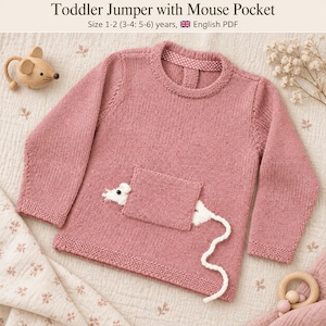 May include: A dusty rose long-sleeved knitted toddler jumper featuring a square front pocket with a white knitted mouse head peeking out and a long white knitted tail extending from the side. The text reads Toddler Jumper with Mouse Pocket.