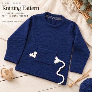 Peut inclure: Un pull tricoté bleu marine à manches longues pour tout-petit avec une poche carrée ornée d'une tête de souris blanche et d'une queue blanche. L'encolure présente un motif à pois bleu marine et blanc. Le texte indique : Digital Product Knitting Pattern Toddler Jumper With Mouse Pocket Size 1-2 (3-4: 5-6) Years.