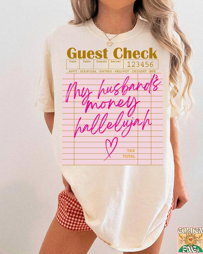 Pu&ograve; includere: Una t-shirt color crema con la grafica di un conto da ristorante. Il testo recita "Guest Check" in alto, "123456" nell'angolo e "My husband's money hallelujah" in corsivo rosa brillante, accompagnato da una piccola icona a cuore.