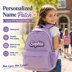 Puede incluir: Una mochila color lavanda con un parche de nombre de PVC personalizado con el nombre Sophia en letra blanca. El parche es impermeable, hecho de goma de PVC duradera y tiene un respaldo de velcro. El texto incluye Personalized Name Patch, Custom PVC Backpack Patch, Waterproof, Durable PVC Rubber, Hook & Loop Backing, Made Just for You, y Make it yours. Wear it proud.