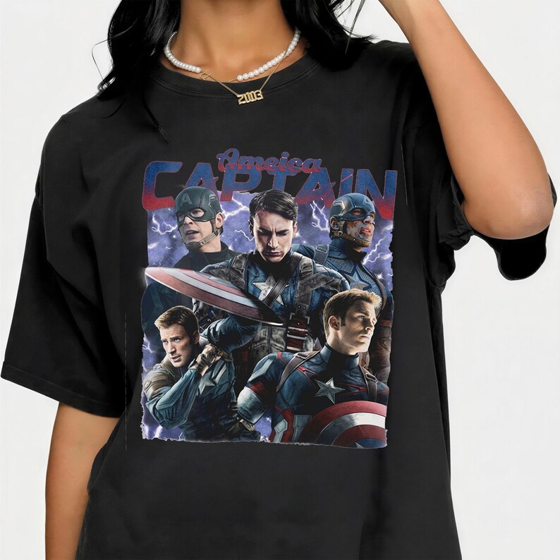 May include: Black t-shirt featuring a graphic of Captain America with multiple images of the character in different poses. The text "America CAPTAIN" is printed across the top of the graphic in blue and red.