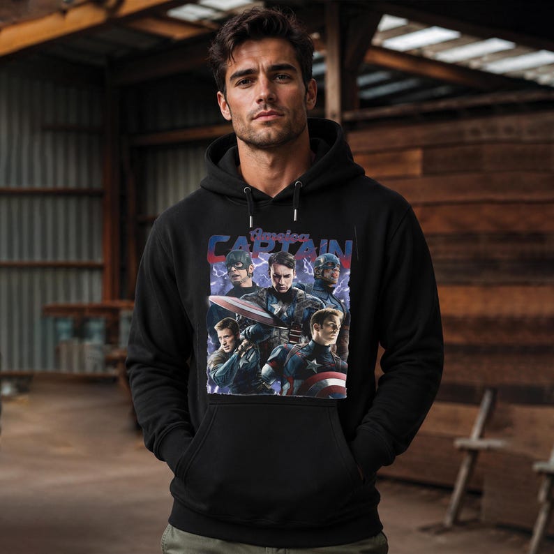May include: Black hooded sweatshirt featuring a graphic of Captain America in various poses. The design includes the text "America CAPTAIN" in red and blue. The sweatshirt has a front pocket and a drawstring hood.