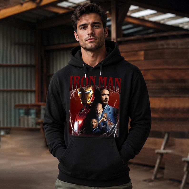 Pu&ograve; includere: Felpa con cappuccio nera con una grafica di Iron Man e la scritta "IRON MAN" in rosso. La grafica include immagini del personaggio nella sua armatura e altri personaggi del film. La felpa ha una tasca frontale e un cappuccio con coulisse.