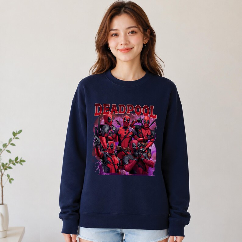 May include: Navy blue sweatshirt featuring a graphic of Deadpool in various poses, with the word "DEADPOOL" in red block letters across the top. The graphic includes multiple figures in red and black costumes. The sweatshirt has long sleeves and a crew neck.