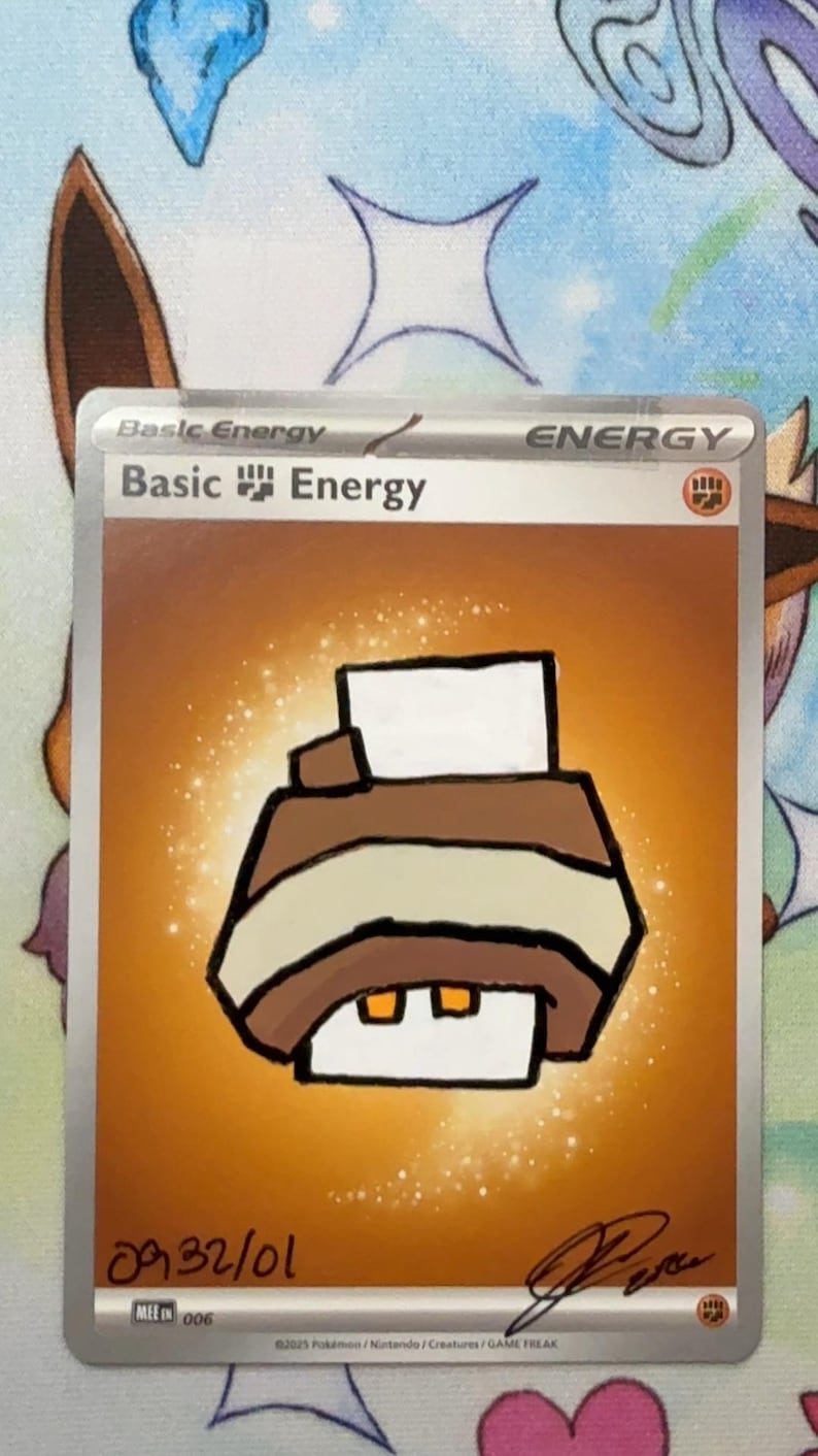 May include: A trading card featuring a hand-drawn illustration of a brown and white printer on an orange background. The card text reads Basic Energy at the top, with a small fist symbol. There is a handwritten date 09/32/01 and a signature at the bottom.