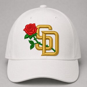 Puede incluir: Una gorra de béisbol blanca con un diseño bordado en la parte delantera. El diseño consiste en una rosa roja con hojas y tallo verdes, entrelazada con las letras SD de color dorado en una fuente de estilo bloque con un borde grueso.