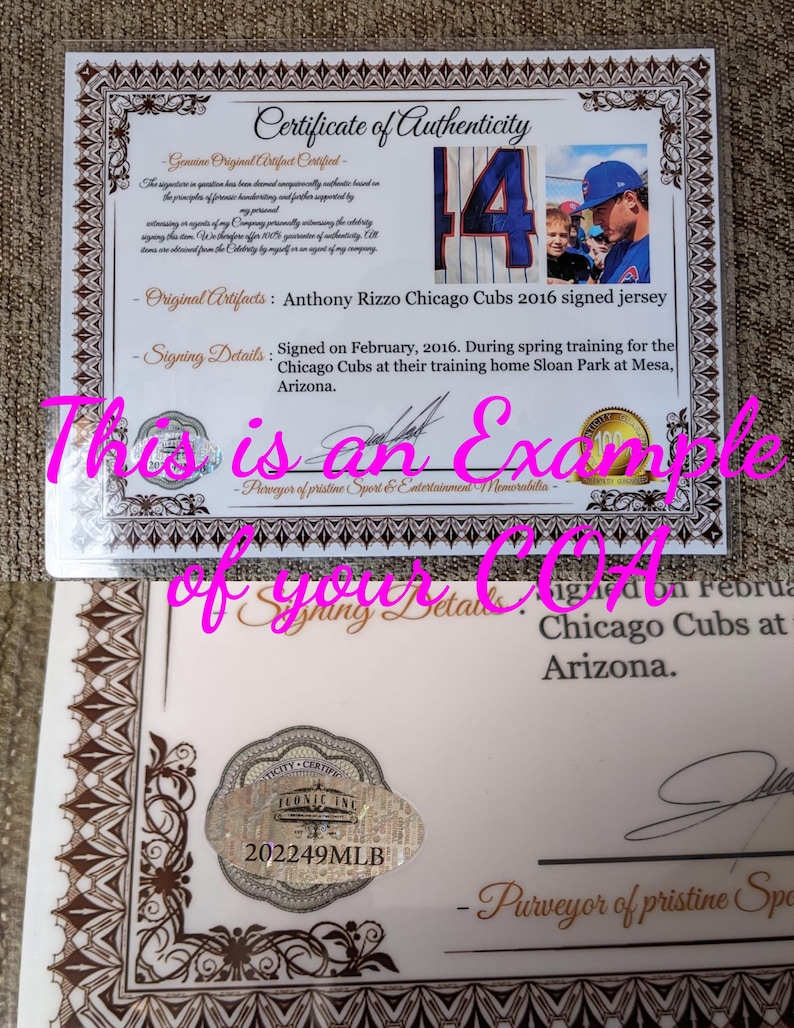 May include: A white certificate of authenticity with brown decorative borders, featuring the text Certificate of Authenticity, details about an Anthony Rizzo signed Chicago Cubs jersey, a photo of the player, and a holographic seal with 202249MLB.