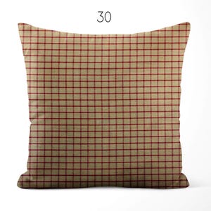 May include: A square throw pillow featuring a tan base color with a repeating thin red grid pattern. The number 30 is printed in black above the pillow. The fabric has a visible woven texture throughout the entire surface of the square cushion.