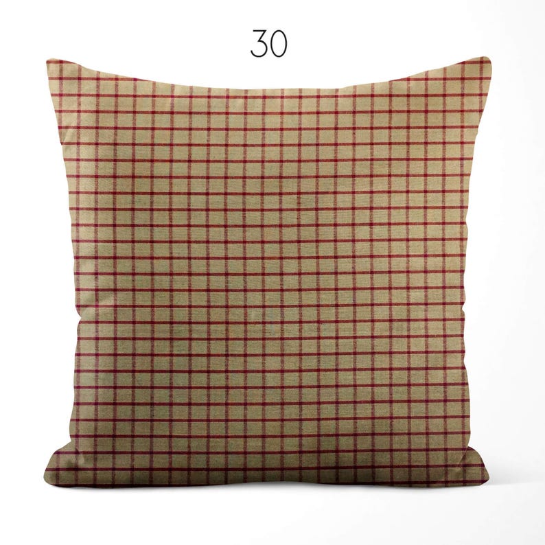 May include: A square throw pillow featuring a tan base color with a repeating thin red grid pattern. The number 30 is printed in black above the pillow. The fabric has a visible woven texture throughout the entire surface of the square cushion.
