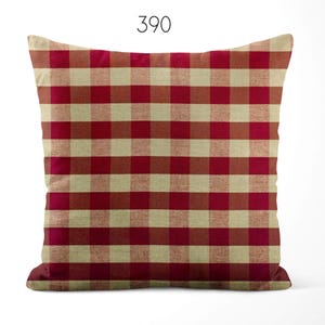 May include: A square throw pillow featuring a red and beige gingham check pattern. The number 390 is printed in black at the top center of the image. The pillow has a textured fabric appearance with a consistent grid design across the entire surface.