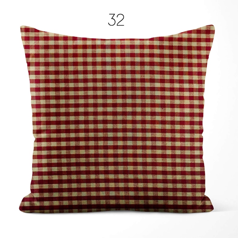 May include: A square throw pillow featuring a red and cream-colored gingham check pattern. The pillow is labeled with the number 32 at the top center. The fabric displays a consistent grid of small, repeating squares across the entire surface.