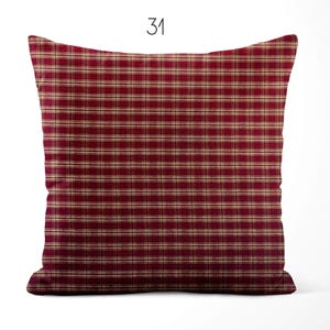 May include: A square throw pillow featuring a deep red and beige plaid pattern with thin horizontal and vertical lines. The number 31 is printed in black at the top center above the pillow. The design consists of a repeating grid of dark red and light tan stripes across the entire surface of the fabric cover.
