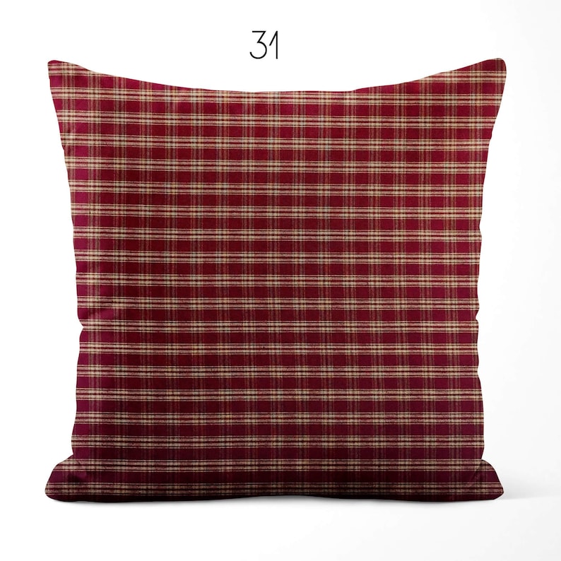 May include: A square throw pillow featuring a deep red and beige plaid pattern with thin horizontal and vertical lines. The number 31 is printed in black at the top center above the pillow. The design consists of a repeating grid of dark red and light tan stripes across the entire surface of the fabric cover.