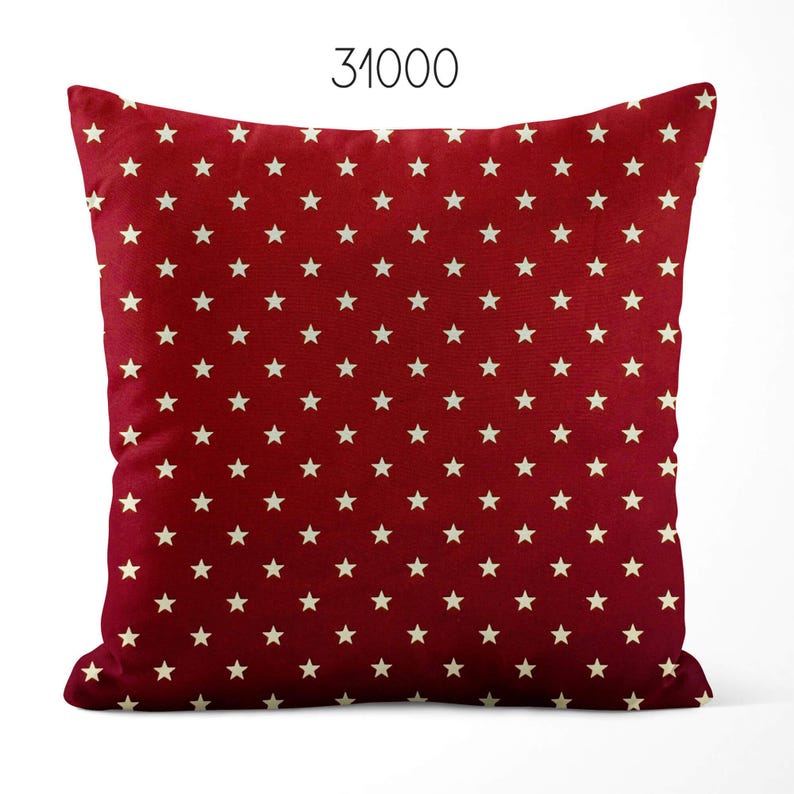 May include: A square throw pillow featuring a deep red background with a repeating pattern of small, off-white five-pointed stars. The number 31000 is printed in black at the top center of the image, positioned above the pillow.