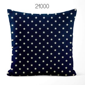 May include: A square throw pillow in a deep navy blue color featuring a repeating pattern of small, white, five-pointed stars across the entire surface. The number 21000 is printed in a simple black font centered above the top edge of the pillow.