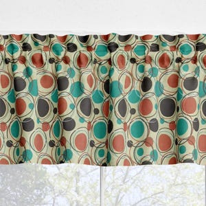 May include: A window valance featuring a repeating pattern of overlapping circles in shades of teal, terracotta, and dark gray on a cream background. The fabric is gathered at the top with a rod pocket header, creating soft vertical folds.