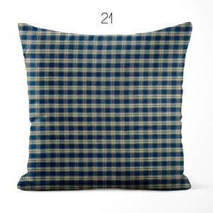 May include: A square throw pillow featuring a dark blue and beige plaid pattern. The design consists of a grid of intersecting horizontal and vertical lines in a consistent check motif. The number 21 is printed in black above the pillow.