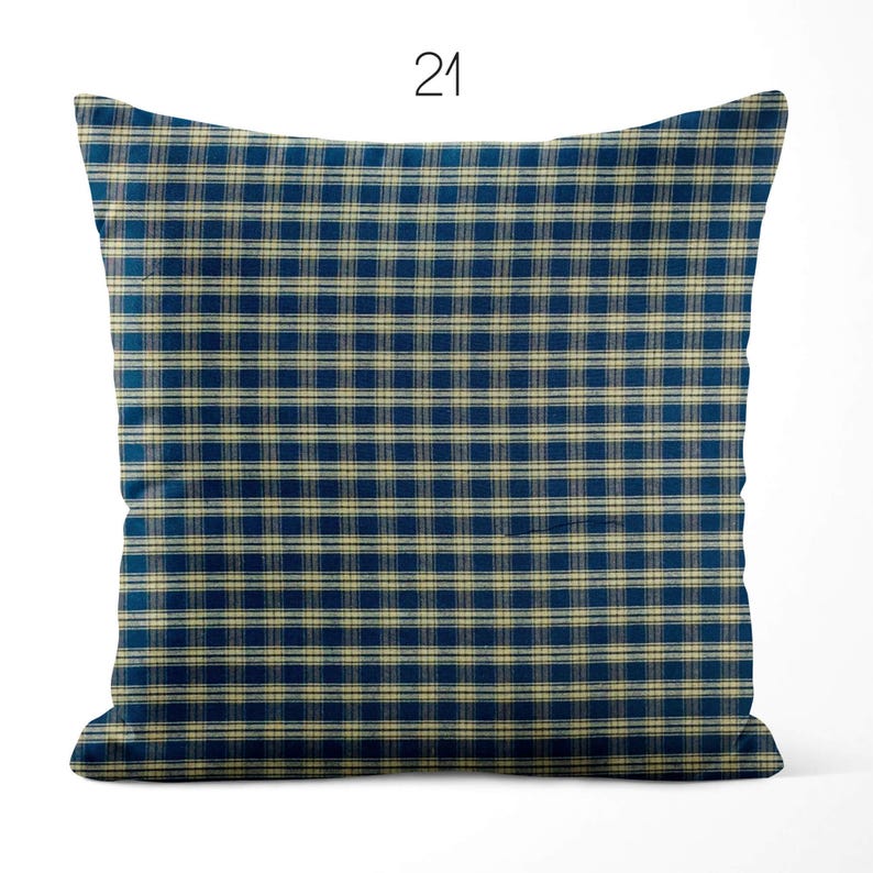 May include: A square throw pillow featuring a dark blue and beige plaid pattern. The design consists of a grid of intersecting horizontal and vertical lines in a consistent check motif. The number 21 is printed in black above the pillow.