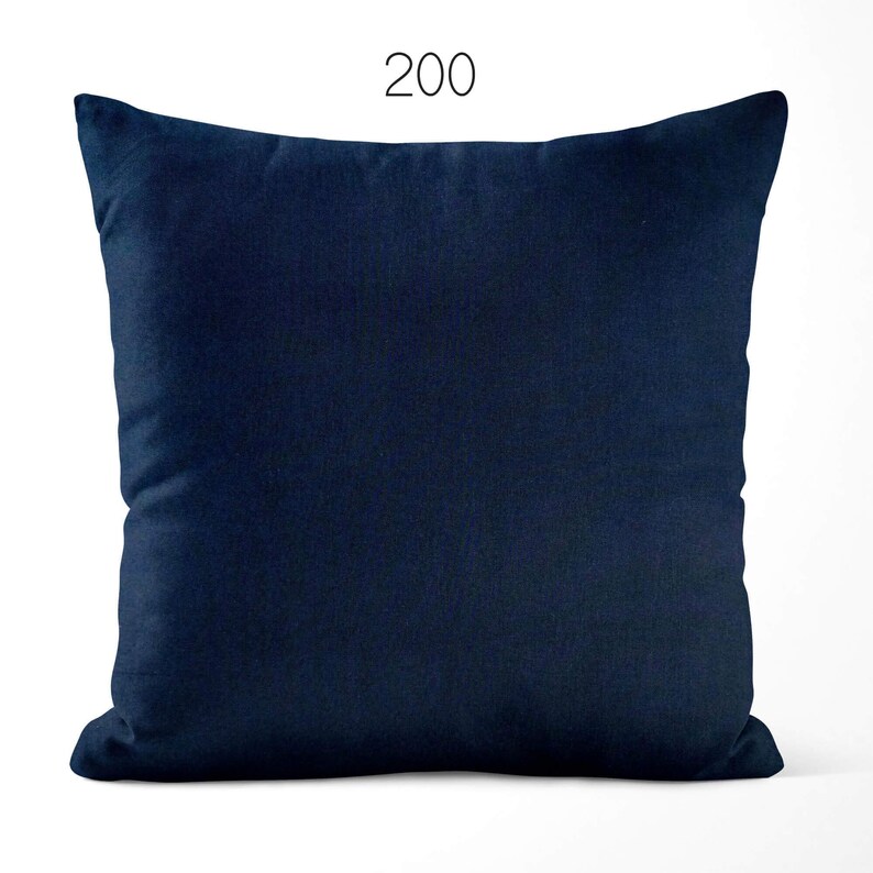 May include: A square throw pillow in a solid dark navy blue color with a smooth, uniform fabric texture. The number 200 is printed in a simple black font centered above the top edge of the pillow, which features clean, straight stitched seams.