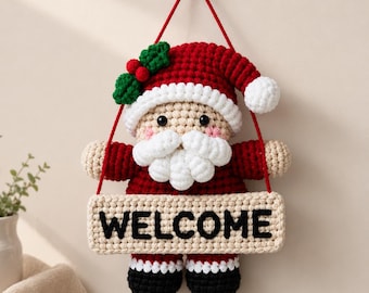 May include: A crocheted Santa Claus wall hanging featuring a red hat with green holly and red berries, a white beard, and a beige face. The figure holds a rectangular beige sign with the word WELCOME in black letters, suspended by a red cord.