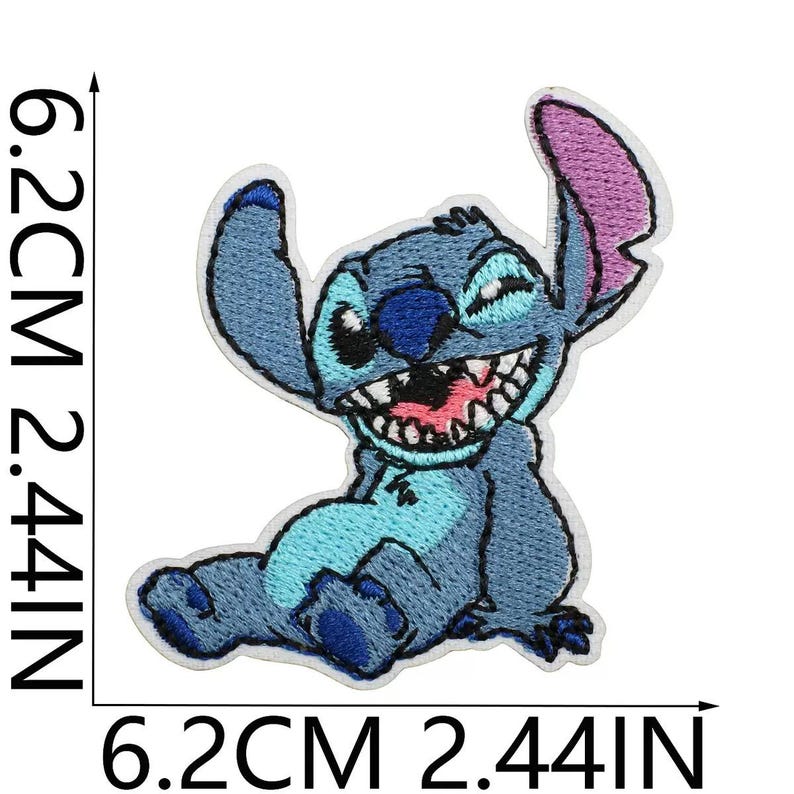May include: An embroidered patch featuring a blue alien character with large ears, a wide grin showing teeth, and a light blue chest patch. The design measures 6.2 cm or 2.44 inches in height and width, as indicated by the black measurement lines.