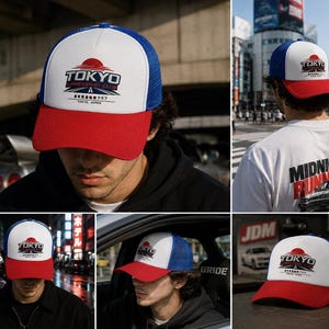 May include: A red, white, and blue trucker hat with the text "TOKYO EXPRESSWAY CLUB" and a rising sun graphic. The hat has a white front panel, a blue mesh back, and a red brim. The text "TOKYO JAPAN" is also visible.