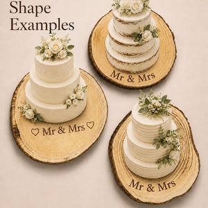 May include: Three round wooden cake stands with natural bark edges, each supporting a three-tiered white cake topped with flowers. The wood surfaces are engraved with the text "Mr & Mrs" and heart symbols. The image includes the text "Natural Rustic Shape Examples".