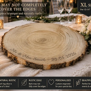 May include: A round wooden cake stand featuring a natural bark edge and visible tree rings. The surface is engraved with the text "Mr & Mrs Smith - 25.04.2026". The product is labeled as XL size for 12-14 inch cakes, noting bark may not cover edges.