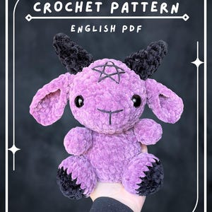 May include: A plush toy made of purple yarn with black horns, black hooves, and black eyes. The forehead features a stitched black pentagram. The text CROCHET PATTERN and ENGLISH PDF is displayed at the top of the image in white lettering.