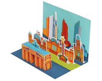 Könnte beinhalten: Eine farbenfrohe 3D-Pop-up-Karte, die die Berliner Skyline zeigt. Die Karte zeigt berühmte Sehenswürdigkeiten wie das Brandenburger Tor, das Reichstagsgebäude und den Berliner Fernsehturm.
