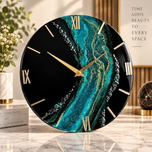 Può includere: Un orologio da parete rotondo caratterizzato da un design in resina marmorizzata nera e verde acqua con numeri romani e lancette color oro. Il quadrante mostra un motivo strutturato e vorticoso di nero profondo e verde acqua con riflessi oro.
