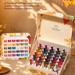 May include: A Beetles Gel Polish set featuring a large open box filled with numerous small nail polish bottles in various colors, accompanied by a color swatch display card labeled Fall Reverie, all decorated with autumn leaf patterns.