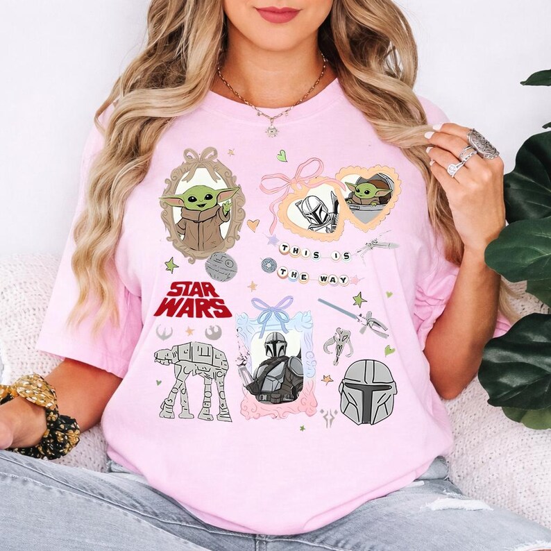 Może przedstawiać: Jasnor&oacute;żowa koszulka z grafiką Star Wars, w tym Grogu, Mandalorianinem i napisem "This is the Way". Projekt zawiera oprawione obrazy i inne elementy Star Wars.