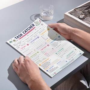 May include: A Task Catcher planning sheet with a white background, pastel-colored sections, and black text. The document features structured fields for task management, including checkboxes, lines for notes, and prompts to organize daily work projects.