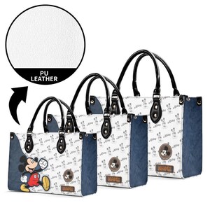 May include: Set of three PU leather tote bags featuring a Mickey Mouse design. The bags have black handles, a white background with a Mickey Mouse pattern, and blue side panels. Each bag has a Mickey Mouse graphic and the word "Mickey".